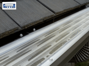 GutterDome gutter guard installed on a shake roof channel, showing the dome design that keeps debris out while water flows through