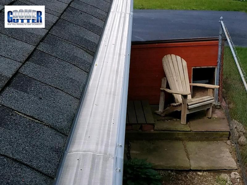 GutterDome GD45A gutter guard above a backyard seating area with an Adirondack chair.
