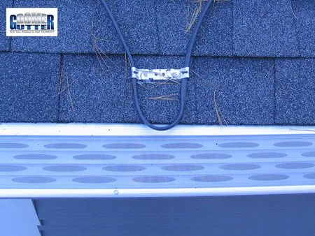 Asphalt shingle roof with GutterDome gutter guard and heat cable — close.