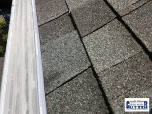 Asphalt shingle roof with a GutterDome gutter guard on a straight run, close view