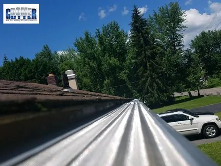 Asphalt shingle roof with GutterDome gutter guard — straight - super close up - white suv.