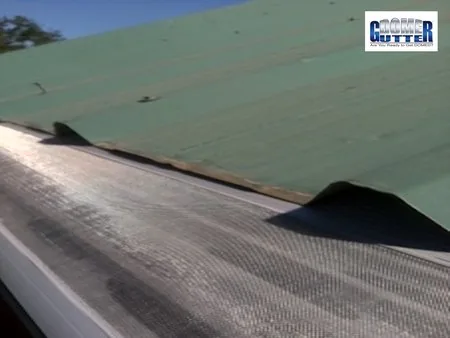 Corrugated metal roof with GutterDome gutter guard — close & light green.