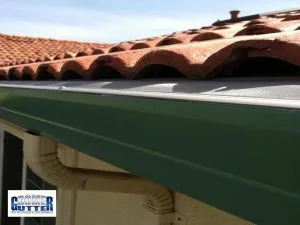 GutterDome GD45 gutter guard installed over a green gutter on a Spanish tile roof