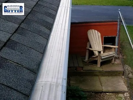 Asphalt shingle roof with GutterDome Adjustable gutter guard — adirondack chair.