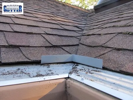 Asphalt shingle roof with GutterDome Adjustable gutter guard — inside corner - diverter.