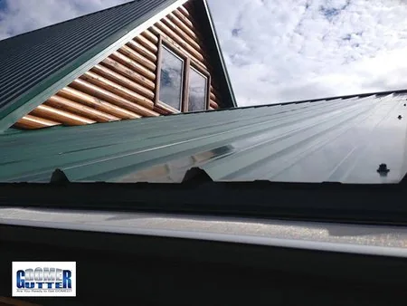 Corrugated metal roof with GutterDome Adjustable gutter guard — straight & dark green.