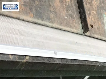 Standing seam metal roof with GutterDome Adjustable gutter guard — straight run - close.