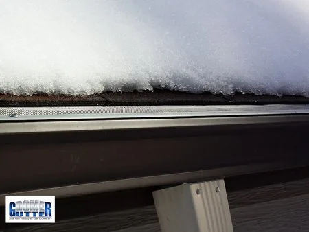 Asphalt shingle roof with GutterDome Magma gutter guard and heat cable — melted snow - side view.