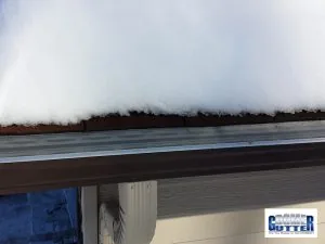 GutterDome Magma gutter guard with heat cable on an asphalt shingle roof, melted snow.