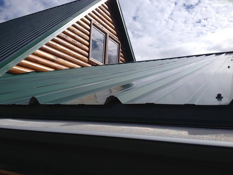 Corrugated metal roof with GutterDome Adjustable gutter guard — straight & dark green