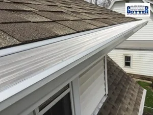 GutterDome gutter guard installed on a second-story asphalt shingle roof, seen from below